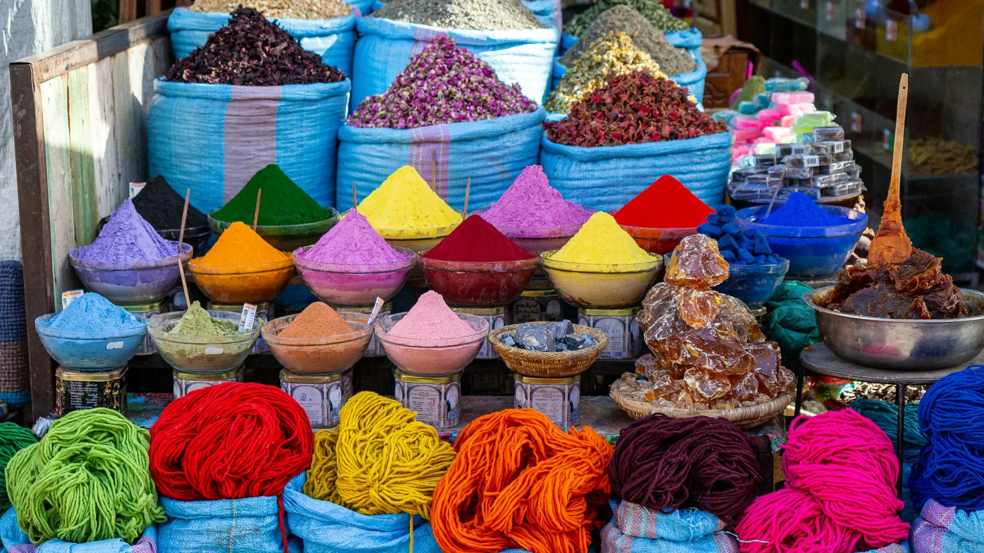 Sacks and baskets of raw goods and spices on display at a market