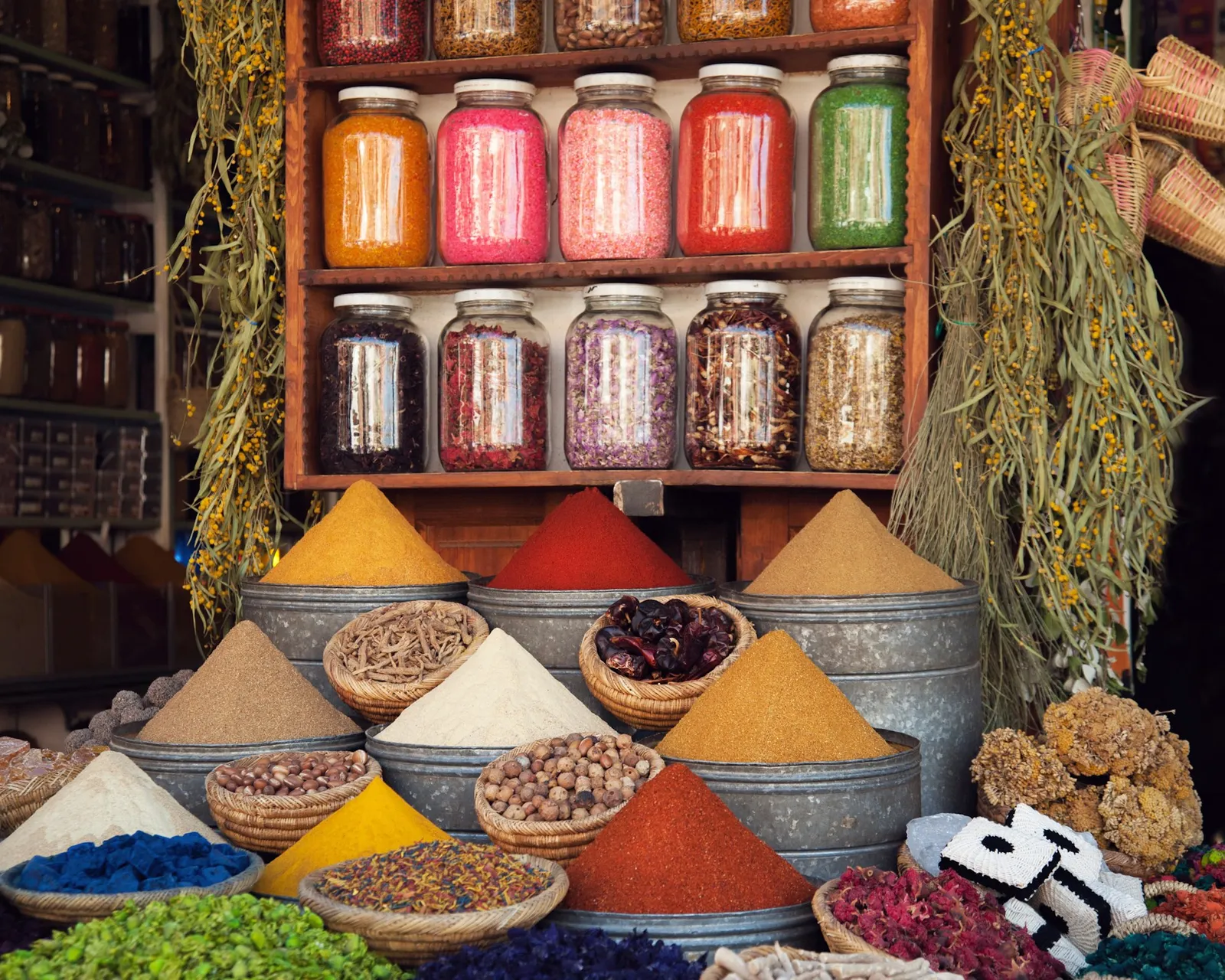 A market display of spices and raw goods in soft natural light